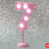 Número 7 gigante color rosa con luces